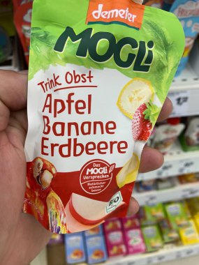 Viersen, Almanya - 9 Temmuz. 2020: Poşet demetresine yakın çocuklar Alman süpermarketinde elle tutulan meyveleri içiyorlar (çantanın merkezine odaklan)