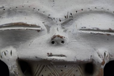 Peru 'dan soyutlanmış, dikdörtgen başlı, beyaz yüzlü, inka kil figürünün yakın çekimi. Siyah arkaplan.