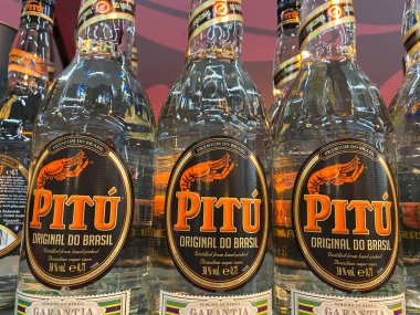 Viersen, Almanya - 9 Temmuz. 2020: Alman süpermarketinin rafındaki Pitu cachaca şişelerine bakın (merkezdeki şişelere odaklanın)