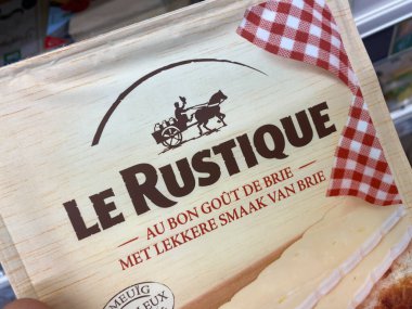 Viersen, Almanya - 9 Temmuz. 2020: Alman süpermarketinin rafında elle tutulan Le Rustique camembert peyniri paketinde görüntüle (paket merkezine odaklan)