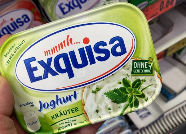 Viersen, Almanya - 9 Temmuz. 2020: Exquisa paketinde görünüm Alman süpermarketindeki rafın önünde elle tutulan peynir (pakete odaklan)