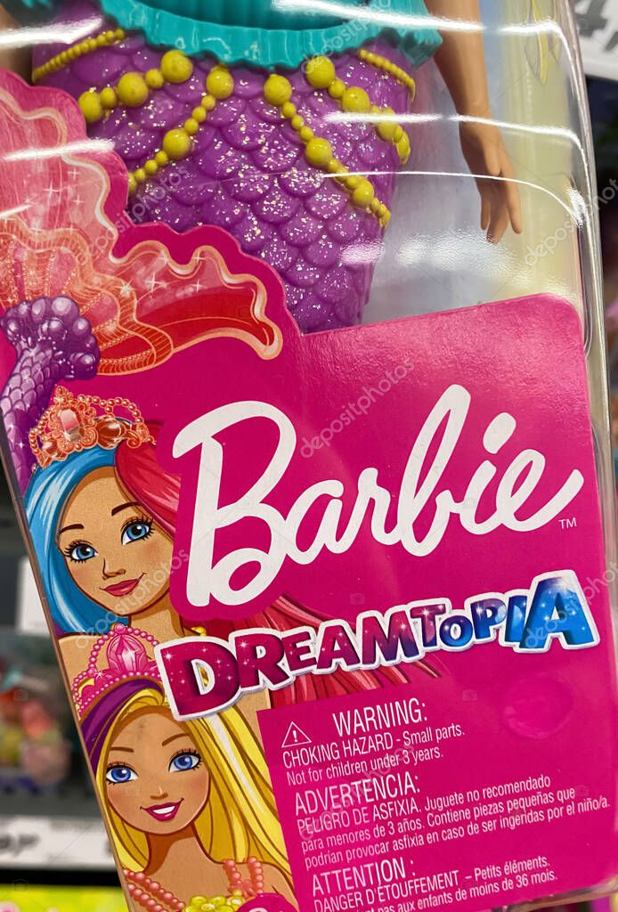 Viersen, Germany - July 9. 2020: View on plastic box with barbie doll in front of shelf in german supermarket (focus on center of box)