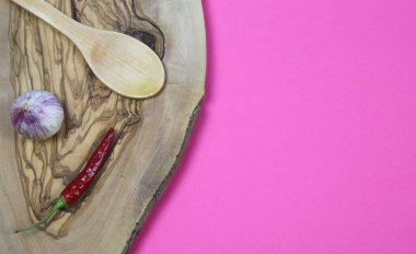 İzole edilmiş zeytin ağacının yüksek açılı görünümü sarımsak karanfil, kırmızı biber ve ahşap kaşık pembe arka planda boş fotokopi alanı (kırmızı biber üzerine odaklan))