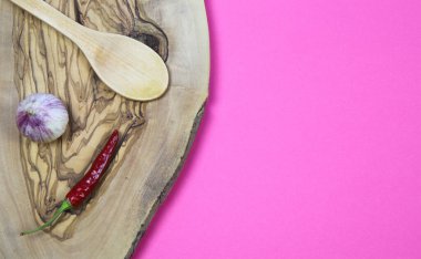 İzole edilmiş zeytin ağacının yüksek açılı görünümü sarımsak karanfil, kırmızı biber ve ahşap kaşık pembe arka planda boş fotokopi alanı (kırmızı biber üzerine odaklan))