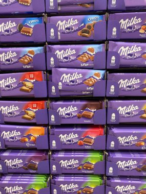 Viersen, Almanya - 9 Temmuz. 2020: Alman süpermarketindeki istiflenmiş sütlü çikolataların çeşitliliğine bak (merkezdeki barlara odaklan)