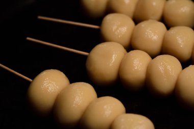Küçük yuvarlak taze Japon dangosu tencerede barbekü için yatıyor.