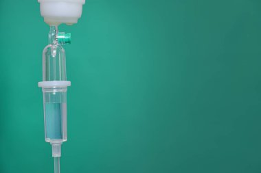Şeffaf ilaçlı bir infüzyon sisteminin detaylarını tıpta metin için alanı olan yeşil bir arkaplan ile kapatma