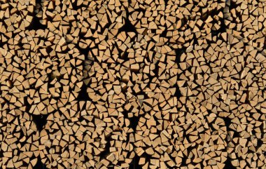 Arka planda bir sürü kesik, bölünmüş ve yakacak odun yığılmış, ki bu da satışa hazır.