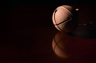 Eskimiş metalden yapılmış yuvarlak bir çan tabana yansıyor.