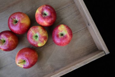 bireysel kırmızı elmalar ahşap bir kutuda yatar ve yukarıdan fotoğraflanırlar.