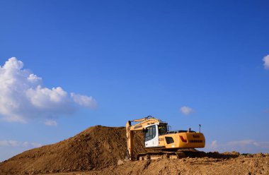 06 / 13 / 2020, Bavyera 'da Augsburg yakınlarında. Sarı bir kazıcı, Almanya 'nın kırsal kesimlerinde mavi bir gökyüzüne karşı duruyor.