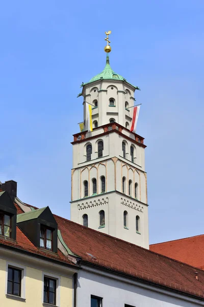 2019 18ドイツのアウクスブルクにある聖モリッツ教会の塔は 市内の住宅を覆う青い空に旗と真っ直ぐな装飾が施されています — ストック写真