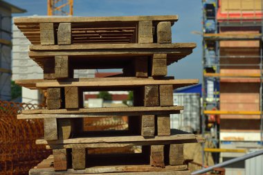 Tahta paletler bir inşaat sahasına istiflenmiş.
