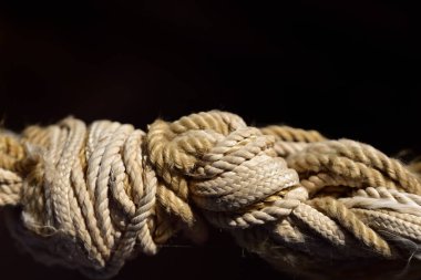 Esrarengiz bir arka planda kenevir ipinin karmaşık ve ayrılamaz bir düğümünün yakın plan görüntüsü