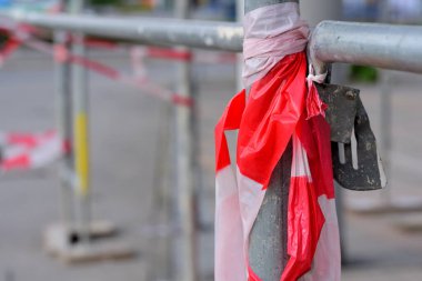 Kırmızı beyaz bir plastikle sarılı, bir inşaat alanında kullanılmış bir yapı iskeleti ile detaylı çekim ve arka plan tehlike uyarısı olarak