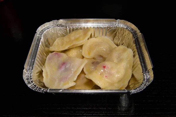 Dumplings with cherry in a foil pan to eat at home