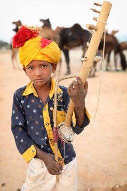 Pushkar, Hindistan - 13 Kasım 2018: Pushkar Camel Fair, Rajasthan'da kimliği belirsiz genç Çingene müzisyen. Fuar Hindistan'ın en büyük deve fuarı..