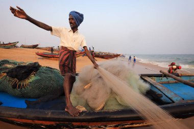 PURI, INDIA - 31 Aralık 2019: Kimliği belirsiz balıkçı Puri, Odisha, Hindistan 'daki geleneksel balıkçı kolonisinin yanındaki plajda
