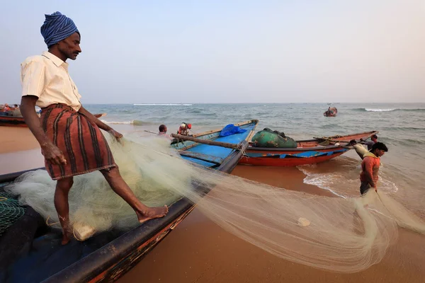 PURI, INDIA - 31 Aralık 2019: Kimliği belirsiz balıkçı Puri, Odisha, Hindistan 'daki geleneksel balıkçı kolonisinin yanındaki plajda