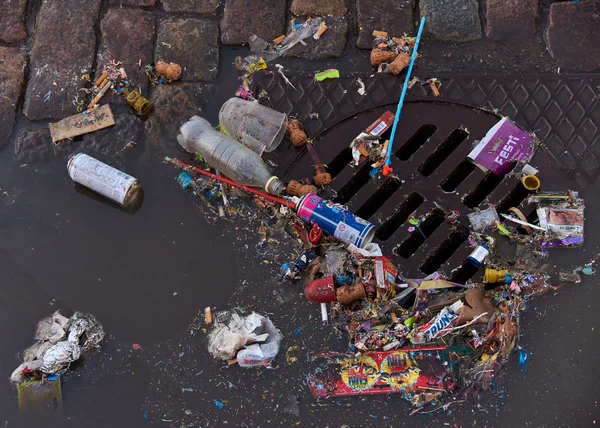 芬兰赫尔辛基 2017 日庆祝活动结束后 塑料和其他垃圾在下水道上 部分漂浮在鹅卵石街道上的水坑中 — 图库照片