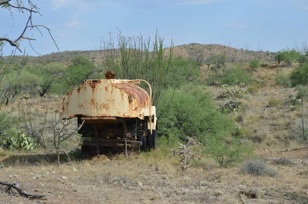 Rusted yellow water tanker abandoned in the desert