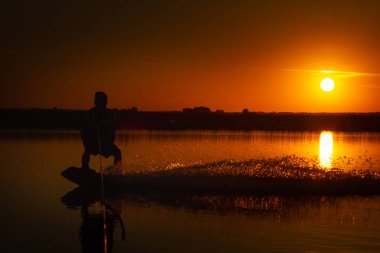 Wakeboarder günbatımı üzerinde hileler yapmak