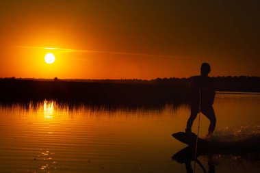 Wakeboarder günbatımı üzerinde hileler yapmak