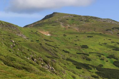 Güzel yeşil dağlar tepeler ve bulutlu mavi gökyüzü.