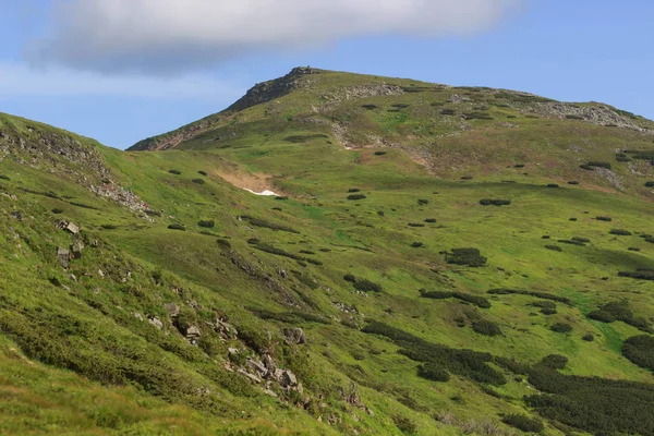 Güzel yeşil dağlar tepeler ve bulutlu mavi gökyüzü.