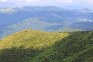 Güzel yeşil dağlar tepeler ve bulutlu mavi gökyüzü.