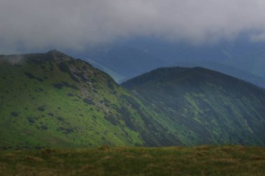 Güzel yeşil dağlar tepeler ve bulutlu mavi gökyüzü.