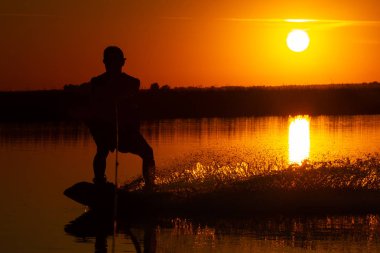 wakeboard, gün batımı arka plan üzerinde atlet siluet.