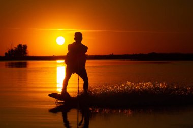wakeboard, gün batımı arka plan üzerinde atlet siluet.