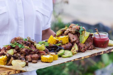 Garson, ızgara et ve sebze sunan.