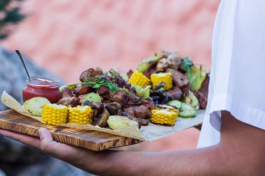 Garson, ızgara et ve sebze sunan.