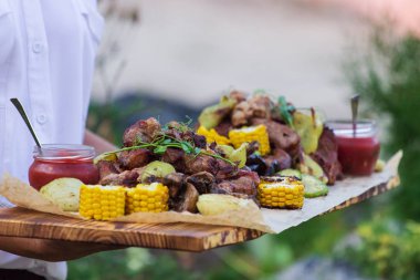 Garson, ızgara et ve sebze sunan.