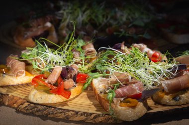 Bruschetta proschuto, domates, kaşar peyniri ve roka ile kapatmak.