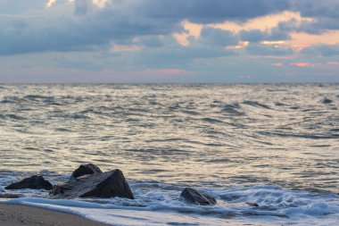 Güçlü dalgalar kayalık bir sahilde eziliyor..