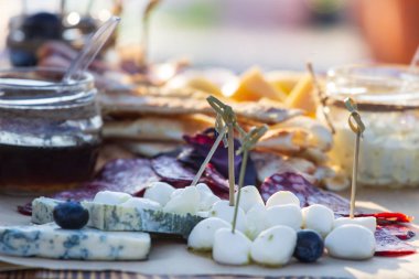 Üzüm, reçeli, incir, kraker ve ahşap arka plan üzerinde fındık ile peynir tabakları servis