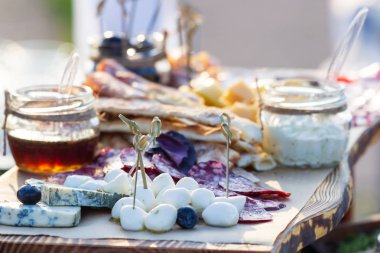 Üzüm, reçeli, incir, kraker ve ahşap arka plan üzerinde fındık ile peynir tabakları servis