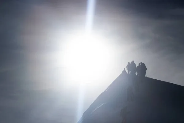 Silhouette of the team on the mountain.
