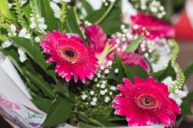 Yeşillikler içinde closeup ile kırmızı ve turuncu Gerbera Buketi.