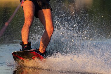Erkekler ayakları üzerinde nehir kenarında oturan water.guy bir wakeboard'ın ve uyku modundan çıkarma yatılı gitmek hazırlanıyor