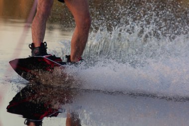 Erkekler ayakları üzerinde nehir kenarında oturan water.guy bir wakeboard'ın ve uyku modundan çıkarma yatılı gitmek hazırlanıyor