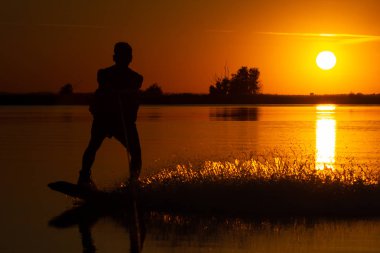Wakeboarder günbatımı üzerinde hileler yapmak