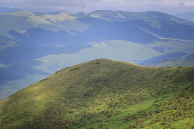 Güzel yeşil dağlar tepeler ve bulutlu mavi gökyüzü.