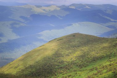 Güzel yeşil dağlar tepeler ve bulutlu mavi gökyüzü.