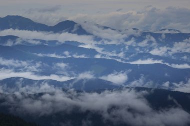 Görünür siluetleri olan dağ siluetleri sabah renkli sislerin arasında