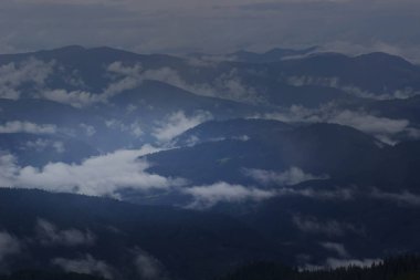 Görünür siluetleri olan dağ siluetleri sabah renkli sislerin arasında
