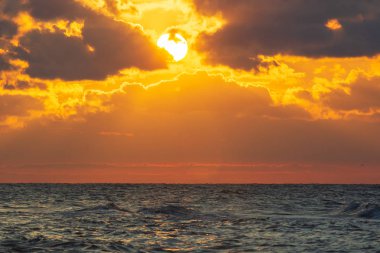 Sahilde ve denizde güzel bir gün batımı.